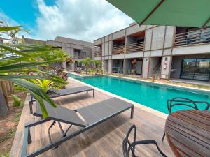 a swimming pool with a table and chairs next to a building at Studio Patacho Rota dos Milagres in Pôrto de Pedras