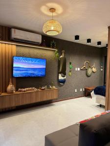 a living room with a flat screen tv on a wall at Studio Patacho Rota dos Milagres in Pôrto de Pedras