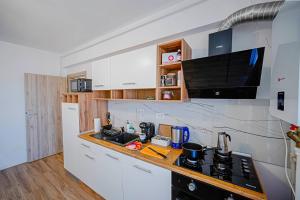 a kitchen with white cabinets and a counter top at ChicStudio Full Kitchen AC Free Parking Popcorn in Chiajna