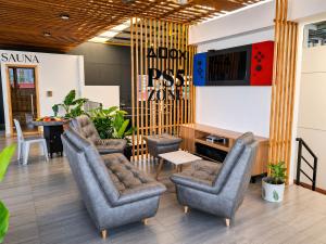 a waiting room with chairs and a tv and a table at Hotel Brisas De Calima in Cali