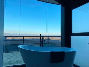 a bath tub sitting in front of a large window at Apalta Vista Wine Lodge in Estación Santa Cruz