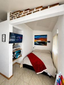 a bedroom with a loft bed and a tv at Alojamiento EYO en Chuy con Baño Privado y Aire Acondicionado in Chuy