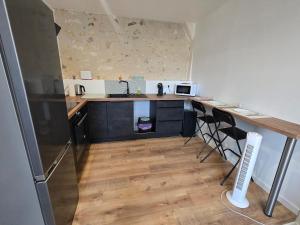 a kitchen with a counter with a sink and a refrigerator at Studio moderne en hyper-centre de Vendôme in Vendôme