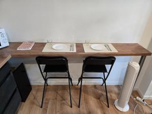 a table with two chairs and two plates on it at Studio moderne en hyper-centre de Vendôme in Vendôme +5 photos