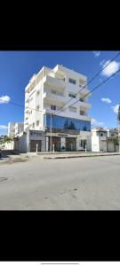 a large white building on the side of a street at Joli Appartement de LUXE in Sousse