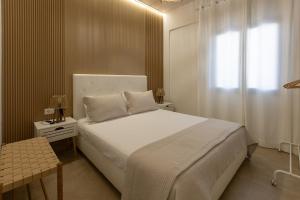 a bedroom with a white bed and a window at Nikolas Apartments in Amoudara Herakliou