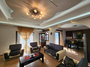 a living room with a couch and chairs and a table at Mihal Suites in Sarandë