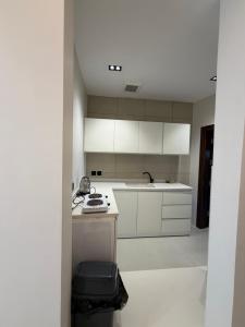 an empty kitchen with white cabinets and a sink at شقق الحصن الفاخره in Al Baha
