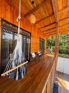 a porch of a house with a hammock on it at Jacaranda House, rustic, Private Pool in Talamanca
