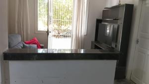 a kitchen with a black counter top and a tv at Casa da Floresta in Vitória