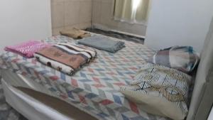 a bed with blankets and pillows on top of it at Casa da Floresta in Vitória