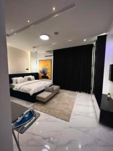 a bedroom with a bed and a couch in it at Fa Apartment in Lekki
