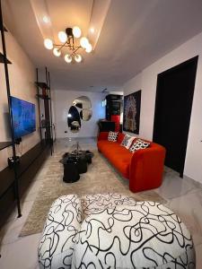 a living room with a red couch and a bed at Fa Apartment in Lekki
