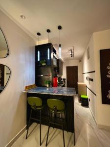 a kitchen with a bar with green stools in it at Fa Apartment in Lekki