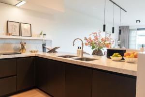 a kitchen with two sinks and fruits on the counter at The Strand Agency - June in Cadzand-Bad +20 photos