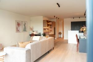 a living room with a couch and a kitchen at The Strand Agency - June in Cadzand-Bad