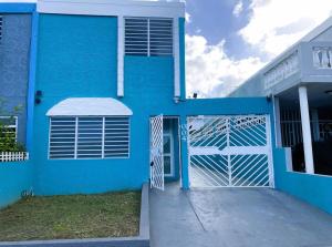 a blue house with a gate in front of it at Modern 4BR Oasis in Bayamón