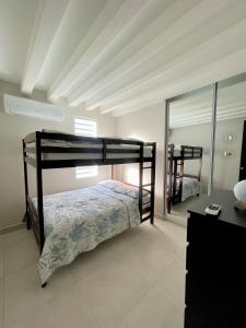 a bedroom with a bunk bed and a mirror at Modern 4BR Oasis in Bayamón