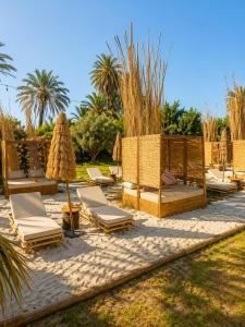 a group of lounge chairs and umbrellas on a beach at Pink lemon Galmping in Elche