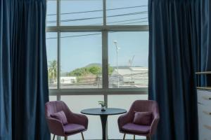 two chairs and a table in front of a window at PGD Blue city view in Rawai Beach