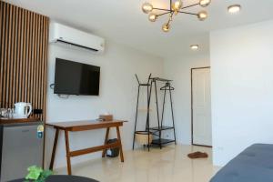 a living room with a tv on the wall and a table at PGD Blue city view in Rawai Beach