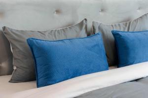 a bed with blue and gray pillows on it at PGD Blue city view in Rawai Beach