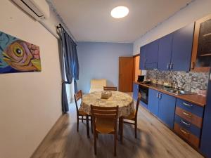 a kitchen with a table and a dining room with blue cabinets at Medoro Piazza Roma Rooms in Milazzo