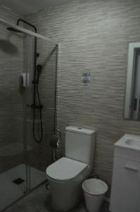 ein Badezimmer mit Dusche, Toilette und Waschbecken in der Unterkunft RI HOSTELs in Madrid