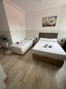 ein Schlafzimmer mit zwei Betten und einem Ventilator in der Unterkunft RI HOSTELs in Madrid