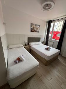 ein Schlafzimmer mit zwei Betten und einem Fenster in der Unterkunft RI HOSTELs in Madrid