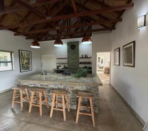 a kitchen with a large stone counter and stools at MANZINI RIVER HOUSE - Mjejane Private Game Reserve, Greater Kruger National Park in Hectorspruit