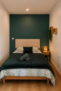 a bedroom with a large bed with a green wall at Terre d'Oasis - HyperCentre in Besançon