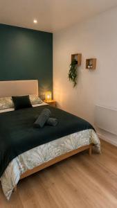 a bedroom with a large bed with a green wall at Terre d'Oasis - HyperCentre in Besançon +10 photos