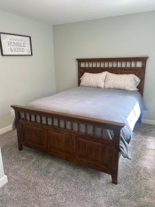 a bed with a wooden frame in a bedroom at Thirty-Six Street Retreat in Missoula