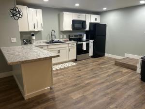 a kitchen with white cabinets and black appliances at Thirty-Six Street Retreat in Missoula