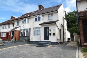 a white house with a driveway in front of it at Luxury Flats - Hendon in Colindale