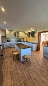 a large kitchen with a counter and stools in it at Agroturystyka Folwark Natura in Wleń