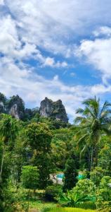 a view of a jungle with palm trees and rocks at Khaosok Bluesky Hotel in Khao Sok National Park