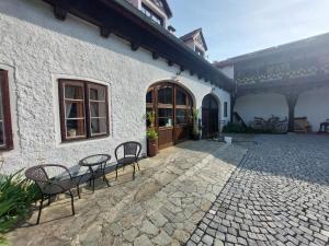a patio with chairs and a table in front of a building at Penzion Manský Dvůr in Dolní Žandov