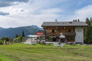 a large building with tables and chairs in a field at Le Flocon d'Argent in Les Gets