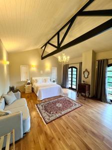 a large bedroom with a bed and a couch at Pousada Casa Florinda in Teresópolis