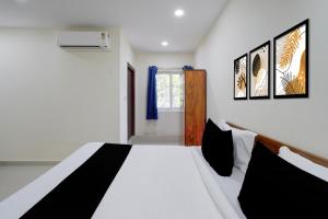 a bedroom with a black and white bed and a window at Hotel O Sree Nirvi in Ameerpet