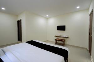 a white room with a bed and a television at Hotel O Sree Nirvi in Ameerpet