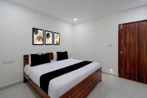 a bedroom with a large bed with black and white sheets at Hotel O Sree Nirvi in Ameerpet