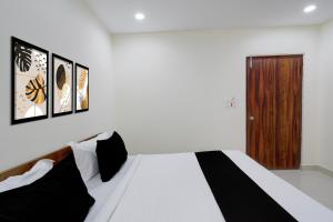 a bedroom with a bed with three pictures on the wall at Hotel O Sree Nirvi in Ameerpet +86 photos