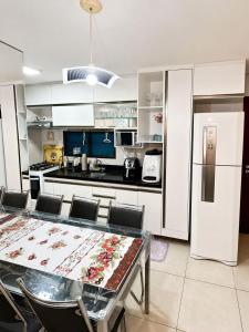 a kitchen with a table with chairs and a refrigerator at WaiWai Residence Cumbuco in Caucaia