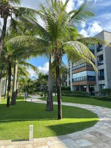 a group of palm trees in front of a building at WaiWai Residence Cumbuco in Caucaia