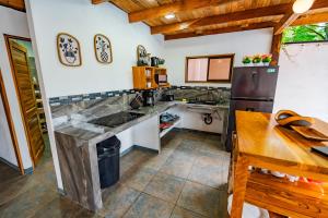 a kitchen with a counter and a refrigerator at Jacaranda House, rustic, Private Pool in Talamanca