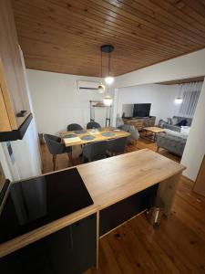 a dining room and living room with a wooden table at Domacinstvo Paprica Tjentiste in Foča