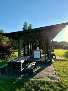 a picnic shelter with a picnic table in a field at Šķilas in Pērkone